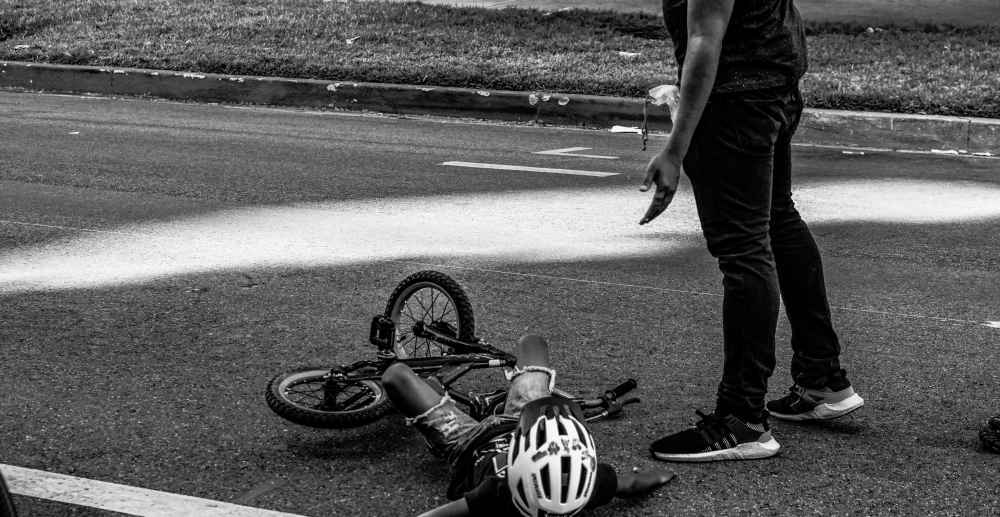 Father helping child who has fallen off his bike